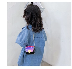 Détail du sac dégradé violet avec boucle cœur dorée et bandoulière en chaîne fine