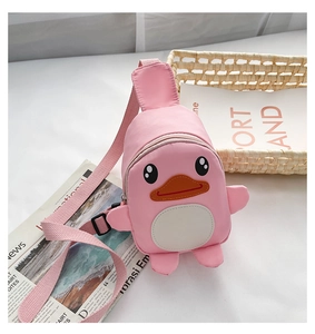 Detail view of a pink cartoon duck crossbody bag for kids on a clean white desk setup