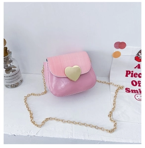 Détail du mini sac bandoulière rose avec une grande boucle coeur dorée et une chaîne