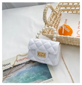 Detail view of mini white jelly purse with quilted texture and elegant pearl handle