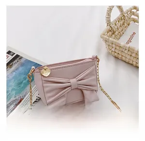 Detail of pink girls' bow bag showing the heart zipper and elegant gold chain strap