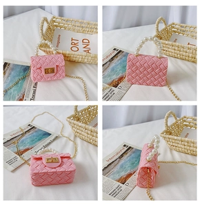 Detail view of pink quilted jelly bag with pearl handle and golden chain strap