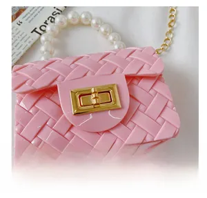 Detail of pink jelly crossbody bag featuring faux weave texture and pearl handle