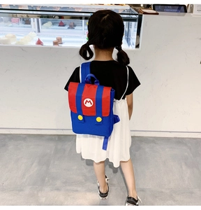 Rear view of child wearing Mario-themed backpack with red 'M' logo in shop