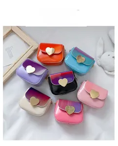 Détail de sacs bandoulière pour enfants en cuir dégradé avec fermoir cœur doré