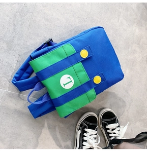 Close-up detail of children's blue and green color-block backpack with L letter design