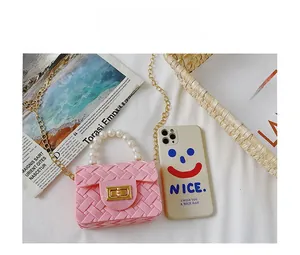 Pink mini jelly bag with pearl handle, gold hardware and chain strap on a white backdrop