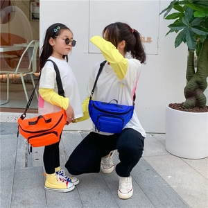 Matching parent and child wearing vibrant nylon crossbody bags in orange and blue