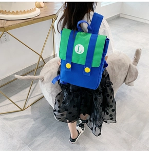 Close-up of kids' cartoon backpack with green and blue contrast and L-shaped letter logo