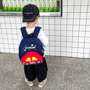 Kids car-themed backpack with cartoon vehicle design worn by child on white background