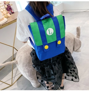 Detail of blue and green kids backpack with white L logo and large yellow buttons