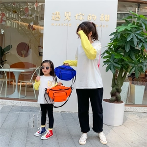 Detail of vibrant blue and orange nylon waist bags with adjustable black straps for kids