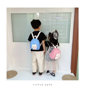 Rear view of pink and blue canvas mini backpacks with cute teddy bear charms on kids