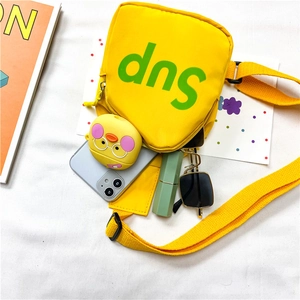 Détail du sac bandoulière en toile jaune montrant sa capacité pour téléphone et objets