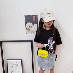 Girl wearing quilted jelly bag with pearl handle and yellow cross-body chain strap