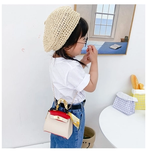 Dettaglio mini borsa per bambini color-block con foulard di seta e chiusura oro