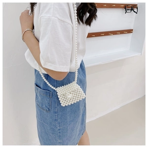 Side view of white pearl beaded mini crossbody bag for kids with chain strap on a model
