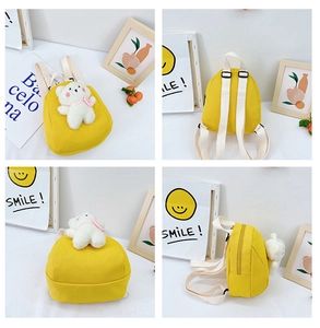 Detail view of mini yellow canvas toddler backpack with cute plush bear and straps