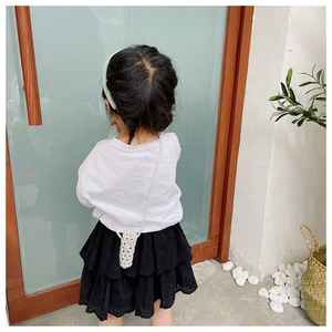 Close-up of child wearing a beaded pearl crossbody bag with a delicate chain strap