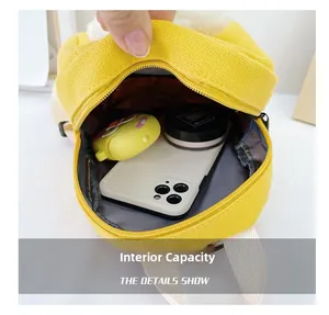 Detail view of yellow canvas toddler backpack interior showing storage space for phone