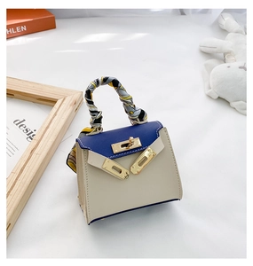 Dettaglio della mini borsa a trapezio con patta a contrasto e manico in seta