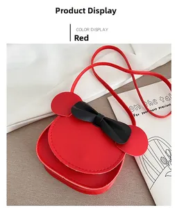 Detail of red mini crossbody bag for kids featuring a black bow and round ear design