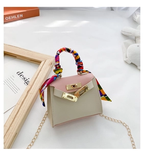 Dettaglio mini borsa Kelly bicolore con manico in foulard di seta e tracolla oro