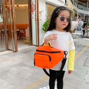 Detail of orange nylon kids waist bag featuring dual zipper pockets and adjustable black strap