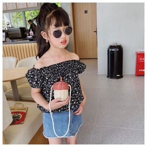 Toddler summer outfit featuring floral top, denim skirt, and acorn shaped straw bag