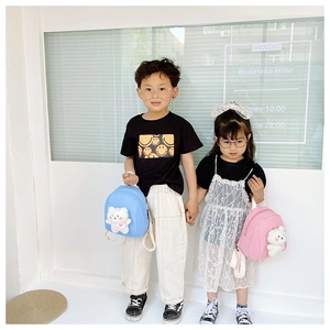 Kids mini backpacks in blue and pink with cute plush bear charms worn by children