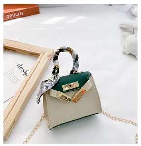 Dettaglio mini borsa stile Kelly bicolore con manico decorato da foulard di seta
