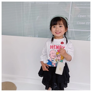 Detail of child wearing a white Henry t-shirt with a mint green headband and pearl mini bag