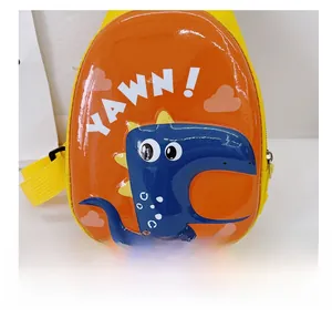 Detail of glossy orange dinosaur egg shell kids crossbody bag with YAWN printed text