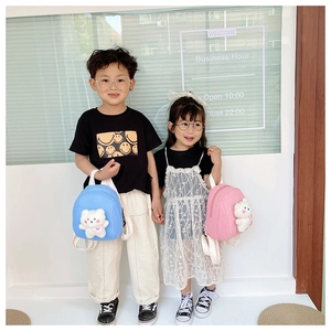 Detailed view of children's backpacks in blue and pink with cute plush bear charms
