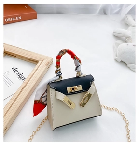 Dettaglio mini borsa bicolore con manico in foulard di seta e catena dorata