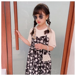 Detail of kids pearl bead handbag styled with summer floral dress and sunglasses
