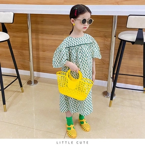 Close-up of children's hollow plastic beach tote bag in vibrant yellow for summer