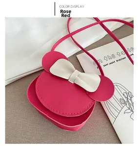 Close-up of rose red mini crossbody bag with cute mouse ears and white bow detail