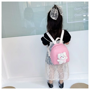 Pink toddler backpack featuring a 3D plush bear worn by a child in a minimalist setting