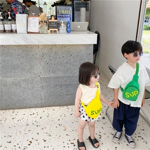 Detailed close-up of canvas kids chest bags in green and yellow with SUP letter print