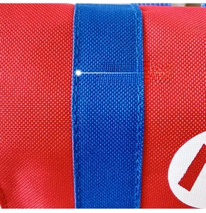 Detail of durable canvas fabric with blue stitching and red M logo on kids backpack