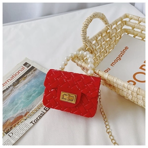 Detail of red jelly crossbody bag with woven texture, pearl handle and gold chain