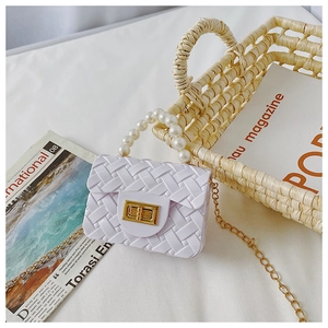 Detail of white mini jelly bag with pearl handle, woven texture and gold chain strap