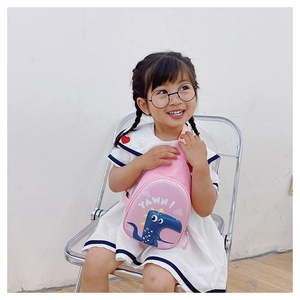 Close-up of pink dinosaur egg crossbody bag with blue cartoon dinosaur and YAWN print