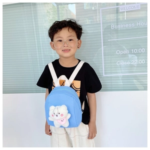 Detail of light blue kids backpack with a cute white plush bear on the front