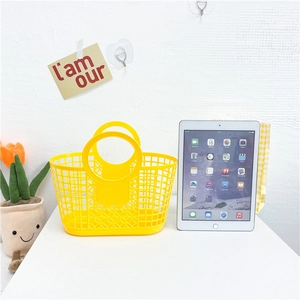 Detail of a bright yellow hollow plastic beach tote bag featuring a large round handle