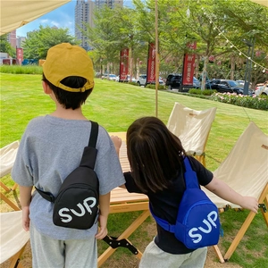 Rear view of children wearing black and blue nylon sports chest bags with SUP letters