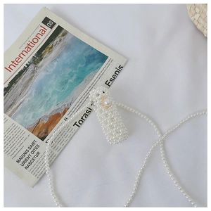 Detail of handmade white pearl mini crossbody bag with long strap and vintage clasp