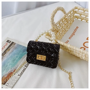 Detail of kids black jelly mini bag with pearl handle and golden chain strap