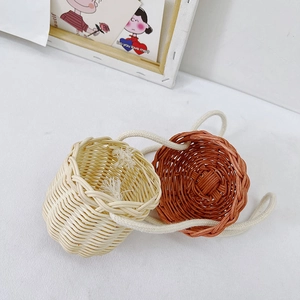 Miniature handwoven rattan shoulder bags for children in beige and terracotta red colors